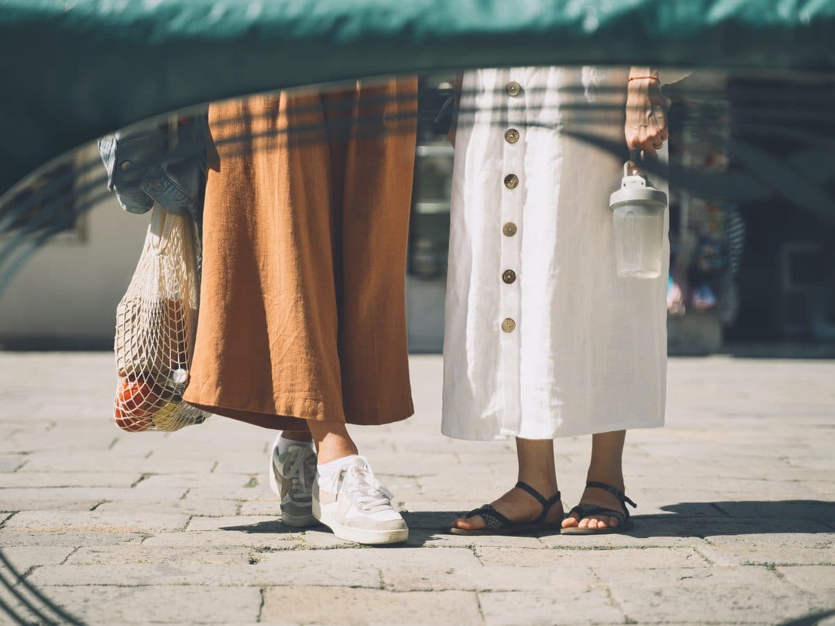 Dos personas paseando por un mercadillo callejero
