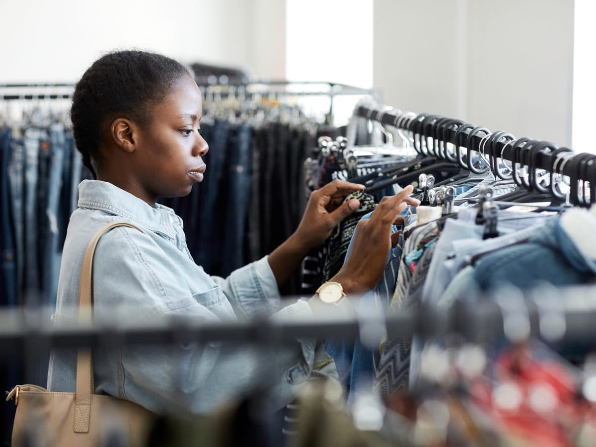 Una persona mirando prendas colgadas en una tienda